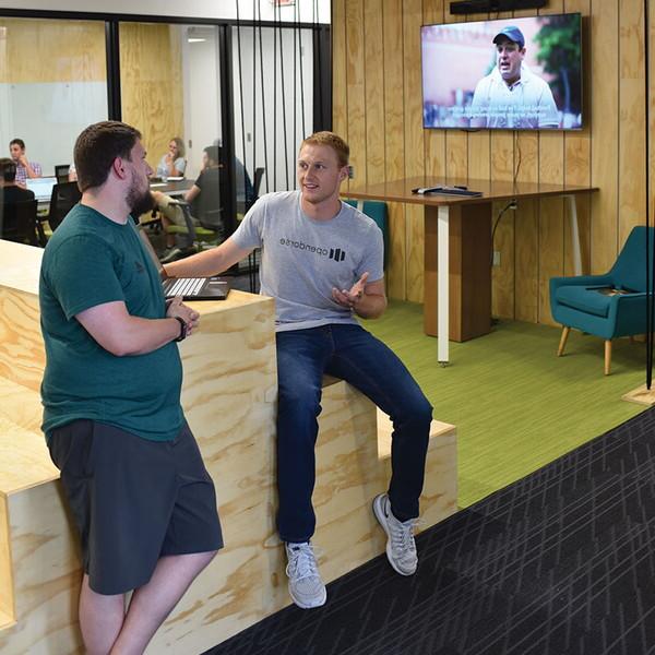 Two young men sitting in a modern workspace